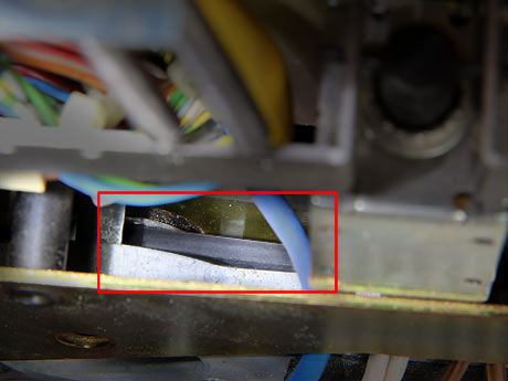 Kontrollblick von vorne oben mit Taschenlampe auf das Tonmotorritzel: Der dunkle Riemen läuft schön gerade. Prima. Rechts oben unscharf das Bremsmagnet mit schwarzem Stössel.